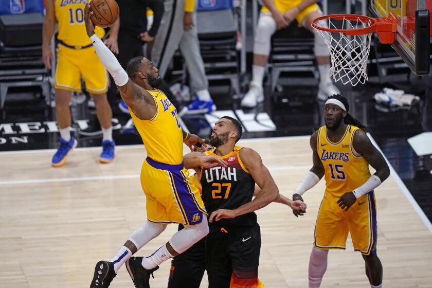 Los Angeles Lakers forward LeBron James, left, goes to the basket as Utah Jazz center Rudy Gobert (27) defends during the first half of an NBA basketball game Wednesday, Feb. 24, 2021, in Salt Lake City. (AP Photo/Rick Bowmer)