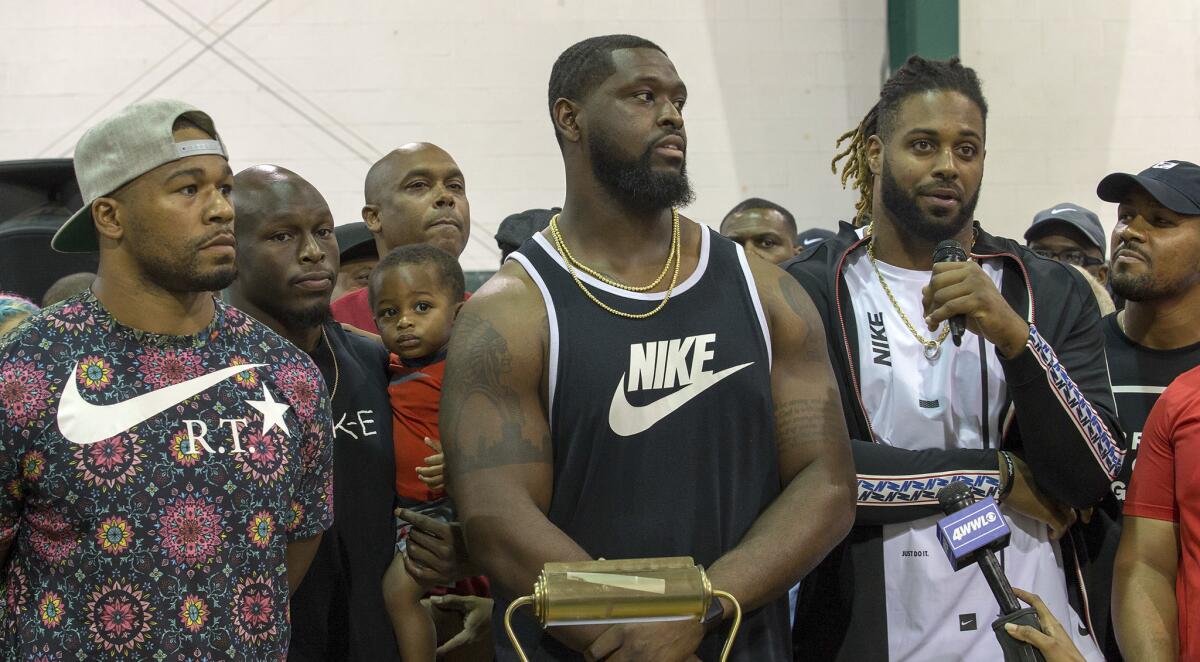 From left, New Orleans Saints Craig Robertson, Chris Banjo (holding his son, Terron Armstead) and Cam Jordan attend the "Unity in Community" rally at Susan Park Playground