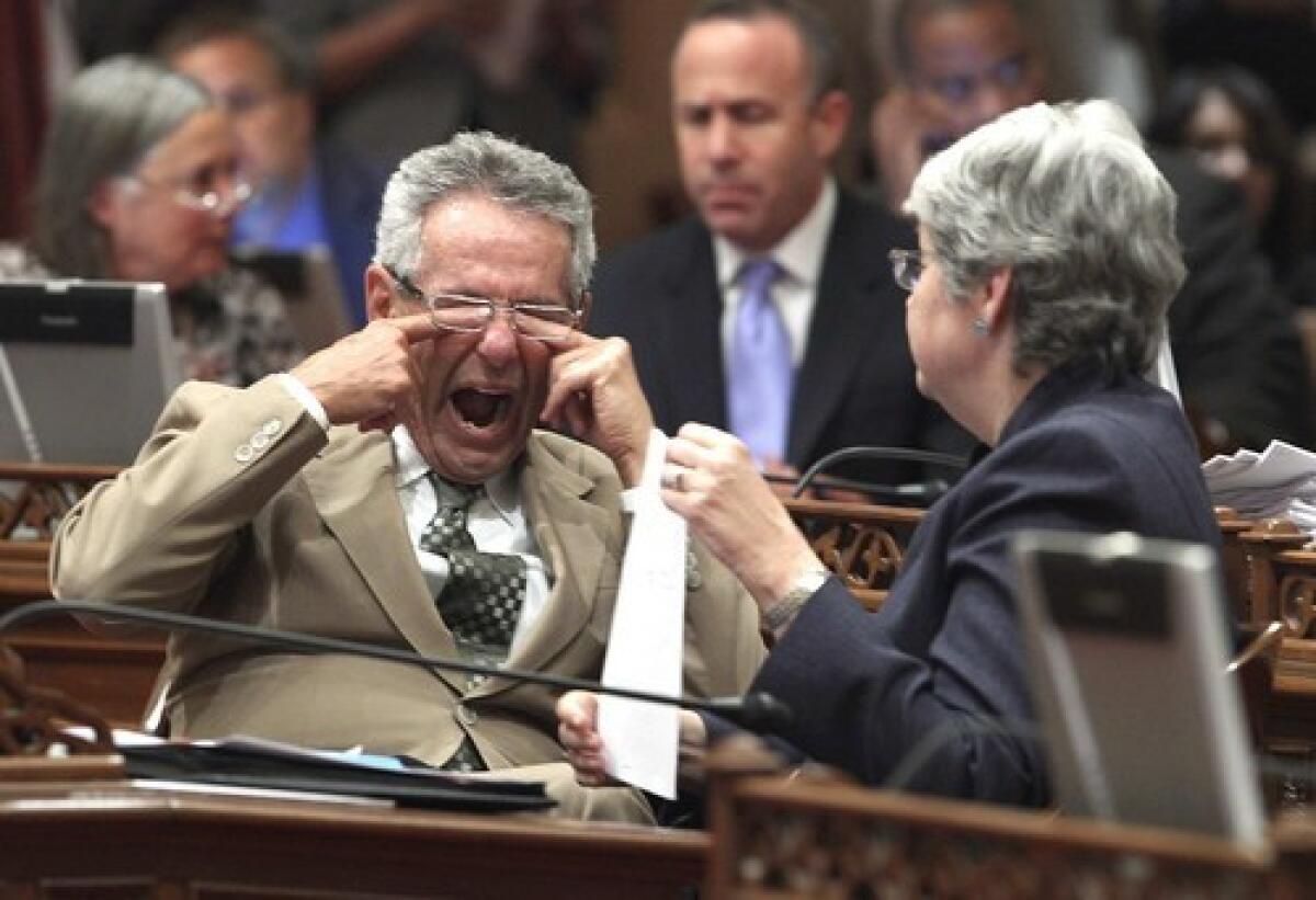 Sen. Alan Lowenthal (D-Long Beach) rubs his eyes and yawns while talking with Sen. Christine Kehoe (D- San Diego) during the overnight session.