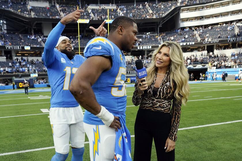 Los Angeles Chargers wide receiver Keenan Allen, left, jokes with linebacker Khalil Mack, center, as Mack conducts a post-game interview with CBS Sports after an NFL football game Sunday, Oct. 1, 2023, in Inglewood, Calif. (AP Photo/Ashley Landis)