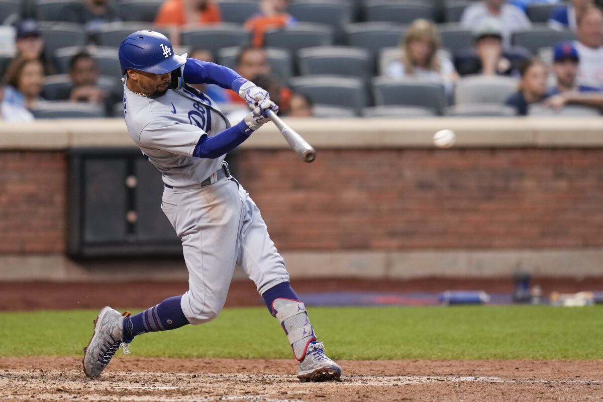 Dodgers' Mookie Betts hits an RBI single in the eighth inning against the New York Mets on July 16, 2023, in New York.