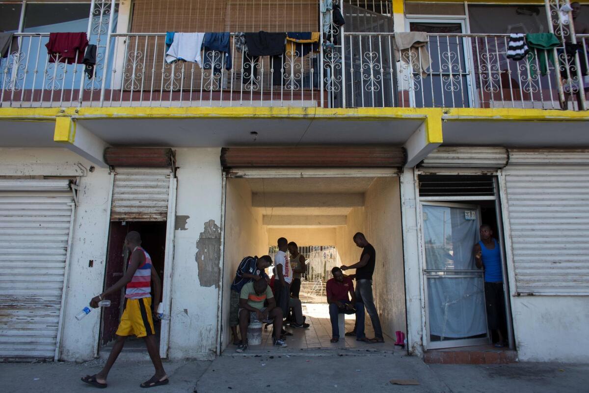 Haitian migrants seeking asylum in the United States wait for the opportunity to get a spot in a room at a rented house in the Mexican border city of Tijuana.
