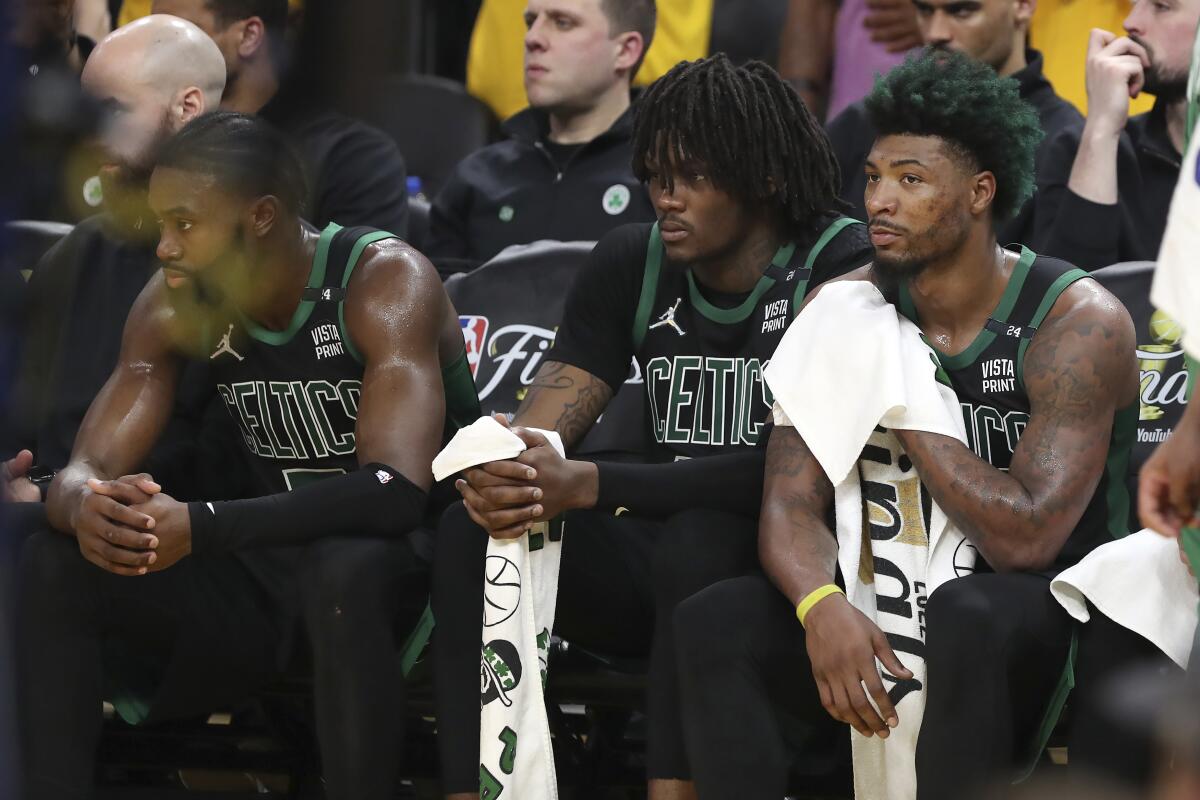 Celtic Jaylen Brown sits on the bench with Robert Williams III and Marcus Smart.