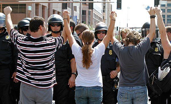 Protesters against Arizona's immigration law join hands as they face a police squad in downtown Phoenix. Full story