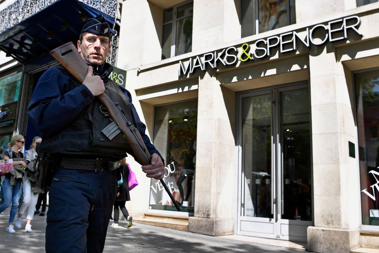 Armed police patrol past a Marks & Spencer on the Champs-Elysees in Paris following the fatal shooting of a police officer on April 21, 2017 in Paris.