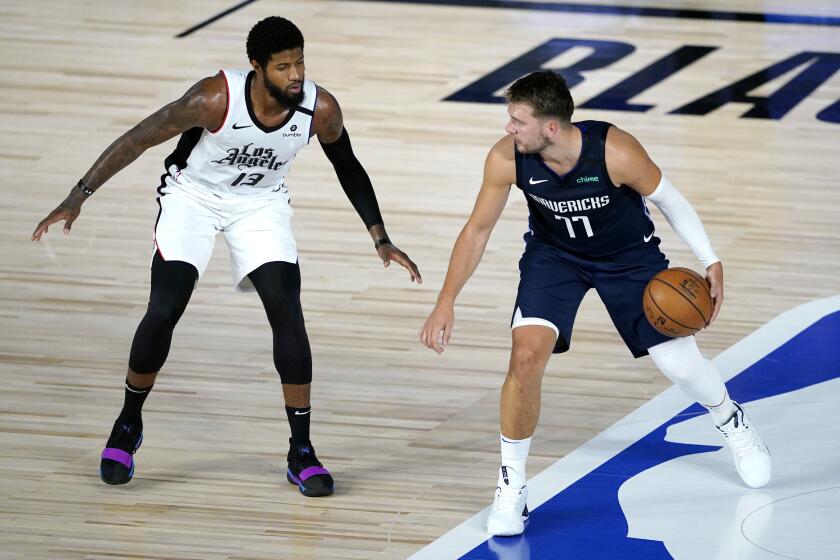 Dallas Mavericks' Luka Doncic (77) works the floor against Los Angeles Clippers' Paul George.