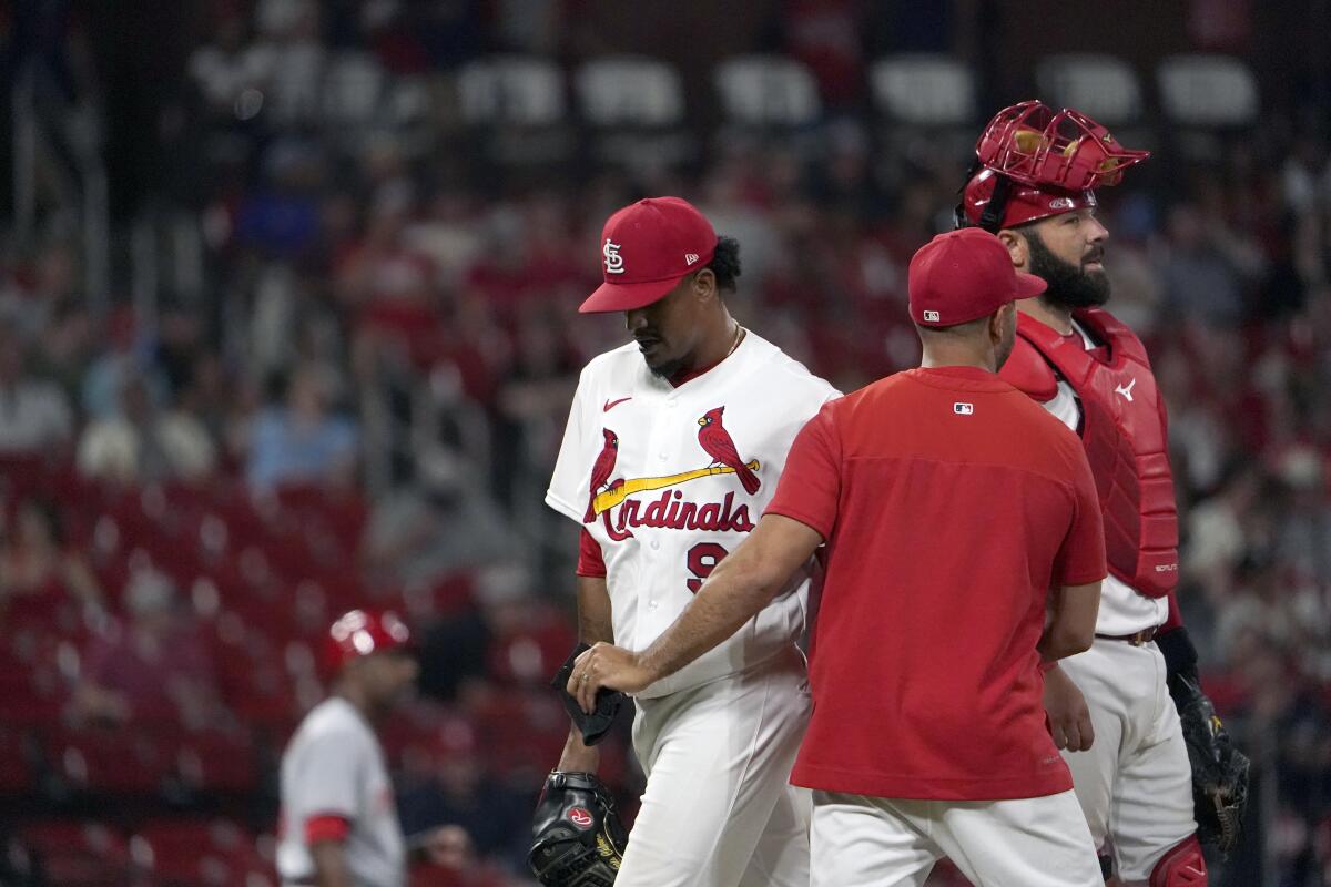 St. Louis Cardinals relief pitcher Genesis Cabrera, left, is removed by manager Oliver Marmol as catcher Austin Romine, right, stands by during the ninth inning of a baseball game against the Cincinnati Reds Friday, July 15, 2022, in St. Louis. (AP Photo/Jeff Roberson)