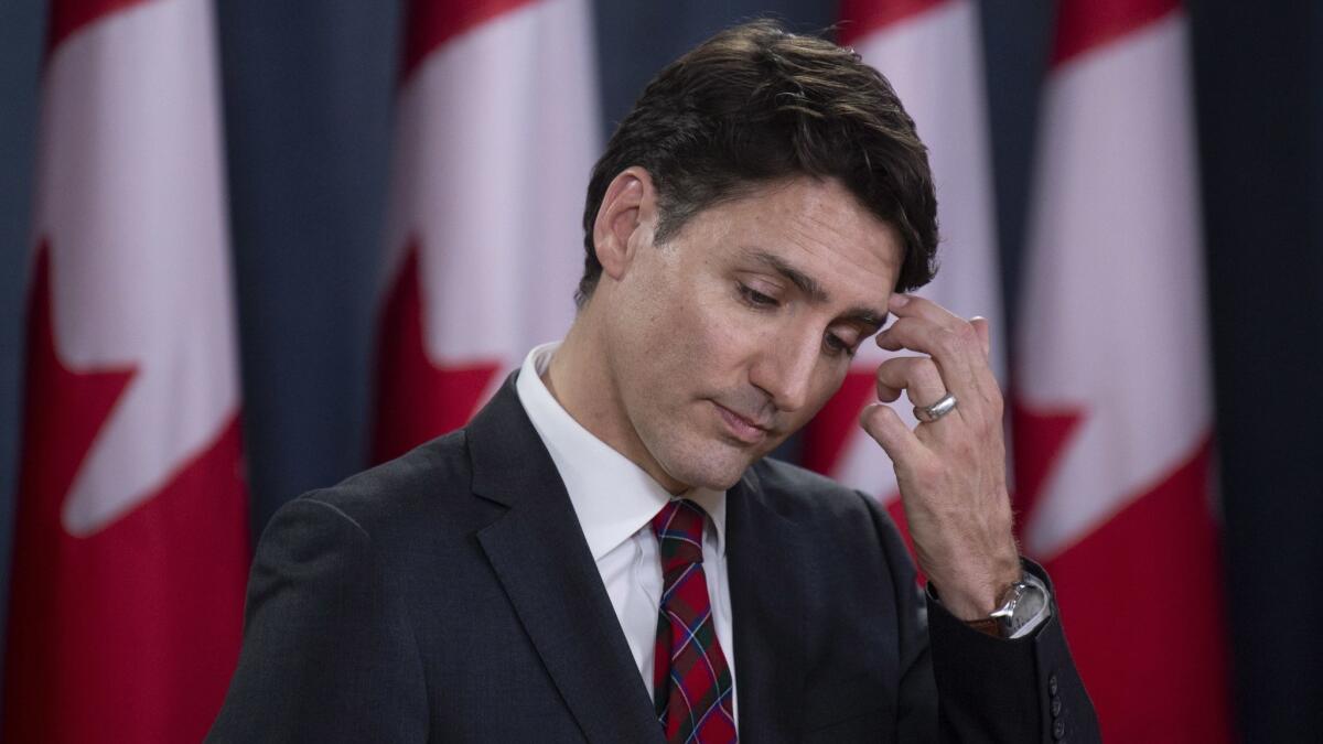 Canadian Prime Minister Justin Trudeau scratches his forehead as he listens to a question during an end of session news conference in Ottawa on Dec. 19.