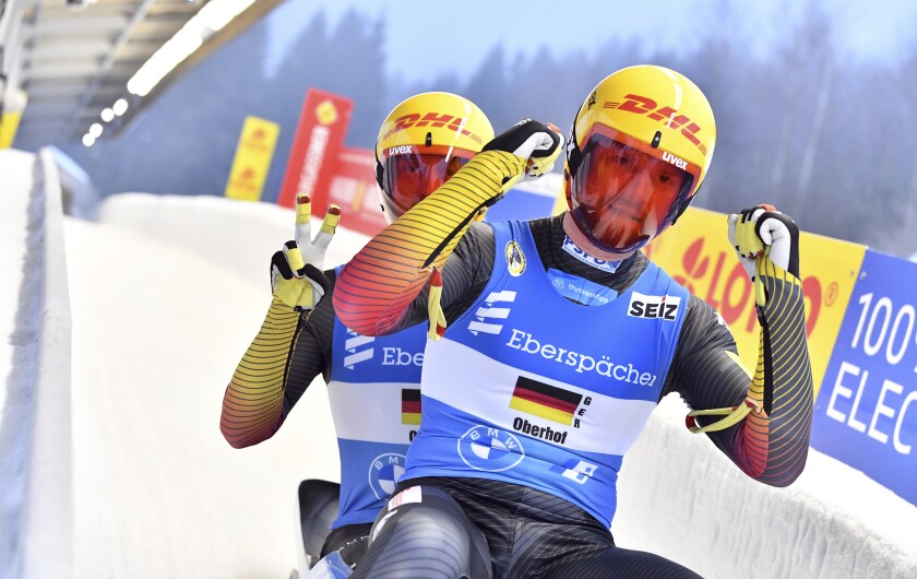Toni Eggert, right, and Sascha Benecken from Germany are happy about the victory in the team relay competition at the Luge World Cup in Oberhof, Germany, Sunday, Jan. 16, 2022. (Martin Schutt/dpa via AP)