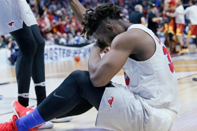 Southern Methodist forward Semi Ojeleye sits on the floor as USC celebrates following their first-round game of the NCAA tournament on March 17.