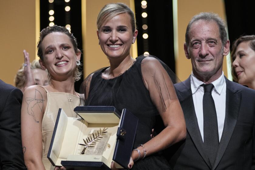 Director Julia Ducournau, center, winner of the Palme d'Or for the film 'Titane' poses with Agathe Roussell, left, and Vincent Lindon during the awards ceremony at the 74th international film festival, Cannes, southern France, Saturday, July 17, 2021. (AP Photo/Vadim Ghirda)