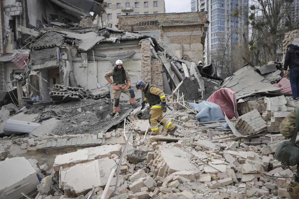 First responders climb amid rubble of a concrete building
