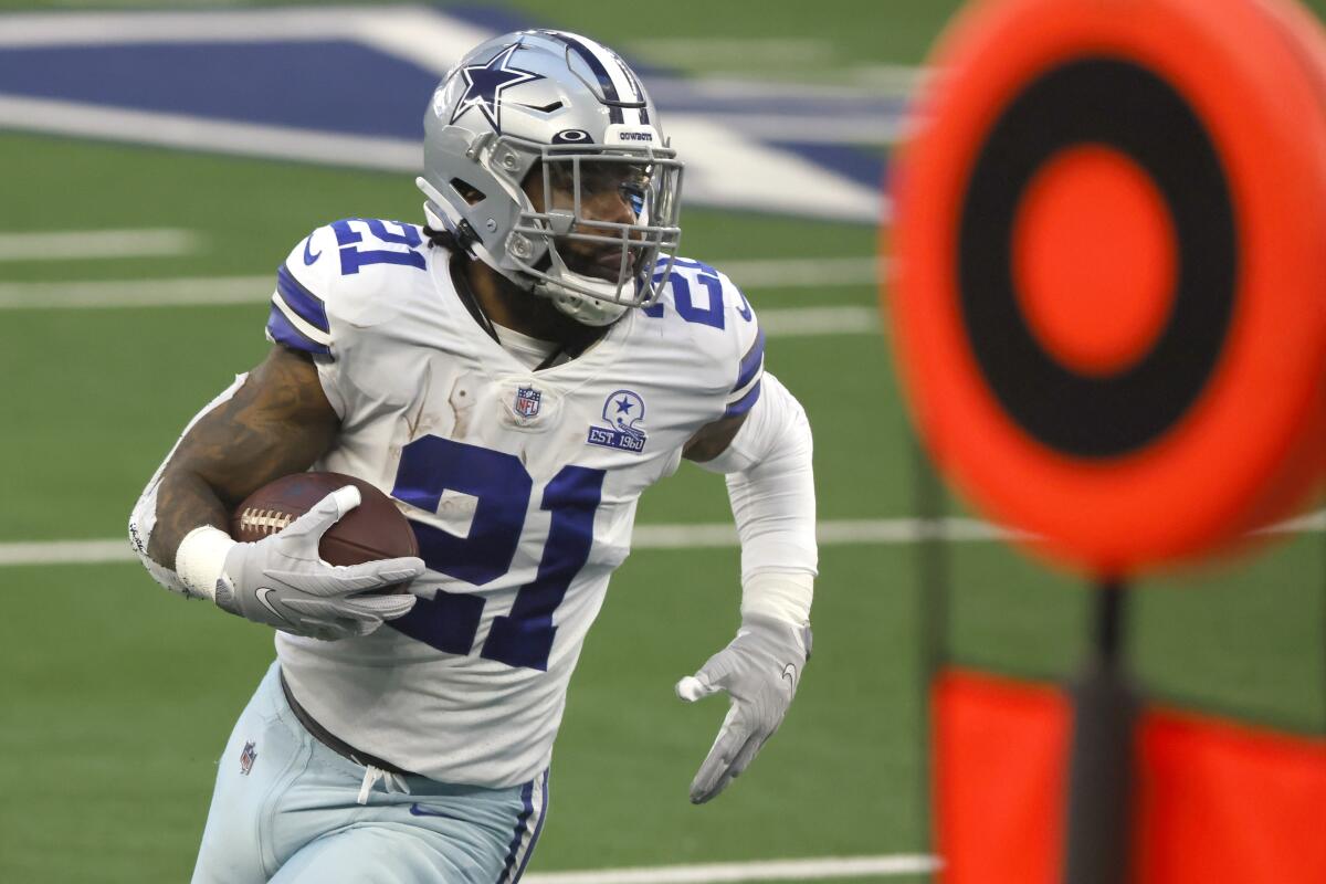 Ezekiel Elliott runs with the football tucked against his body.