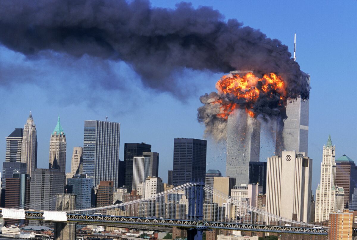 An explosion rips through the south tower of the World Trade Center as smoke billows from the north tower.