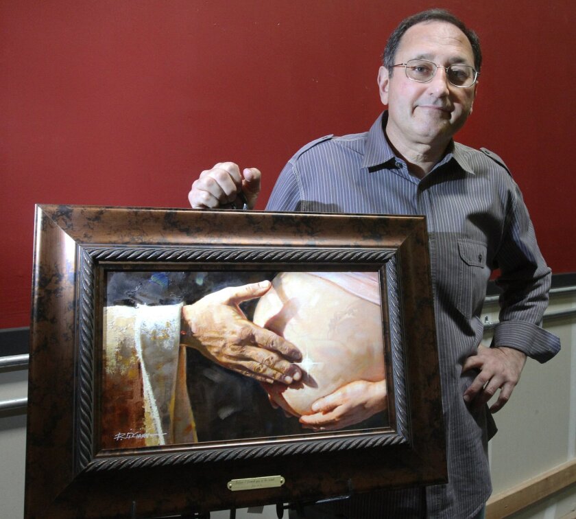 Ron Dicianni stands with a painting that he is distributing to family planning clinics, OB-GYN offices and abortion providers through his nonprofit foundation that aims to spread a pro-life message.
