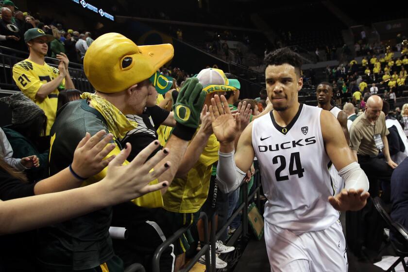 Oregon forward Dillon Brooks (24) high-fives fans after the team defeated Utah, 76-66.