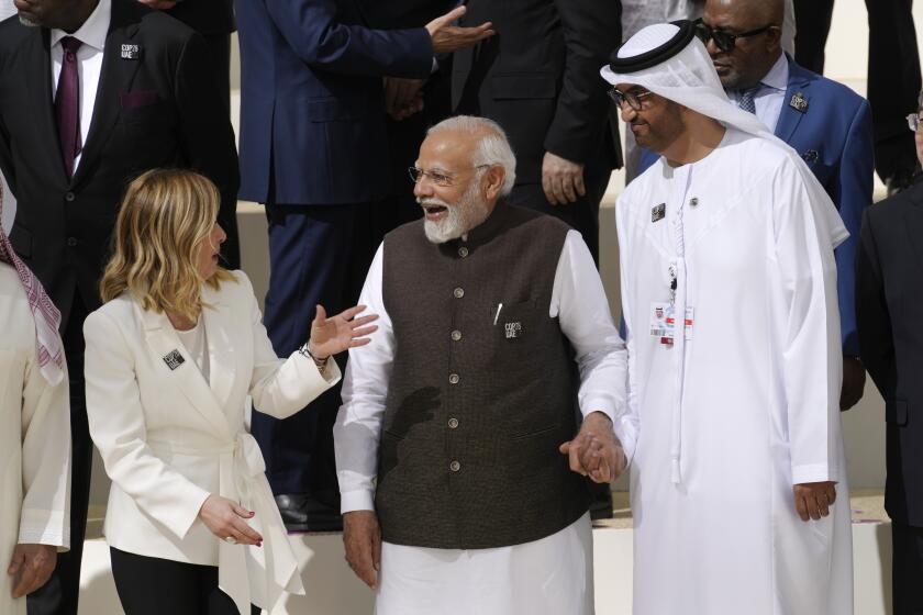 Italy Premier Giorgia Meloni, left, India Prime Minister Narendra Modi, center, and COP28 President Sultan al-Jaber speak at a group photo at the COP28 U.N. Climate Summit, Friday, Dec. 1, 2023, in Dubai, United Arab Emirates. (AP Photo/Peter Dejong)