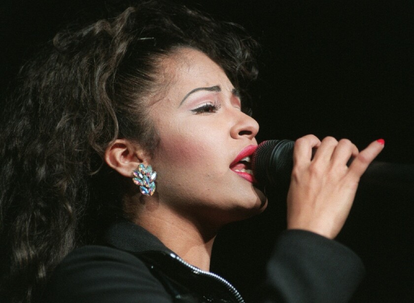 Selena sings into a microphone