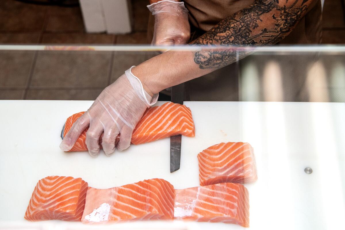 Ryan Lee cuts into a salmon fillet