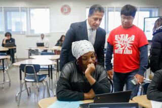 LOS ANGELES-CA-DECEMBER 19, 2022: LAUSD Superintendent Alberto Carvalho, center standing, visits teacher Reynaldo Aquino, right, and senior math student Jaliah Young at John C. Fremont High School in Los Angeles during "acceleration days," two days of optional learning that were moved from the middle of the school calendar to the first two weekdays of winter break, on Monday, December 19, 2022. (Christina House / Los Angeles Times)