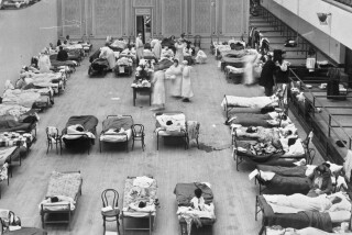 Volunteer nurses from the American Red Cross tend to influenza patients in the Oakland Municipal Auditorium in 1918,