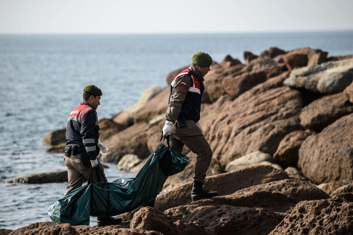 Turkish police carry away the body of a migrant that washed ashore near the Aegean resort of Ayvacik on Jan. 30, 2016.