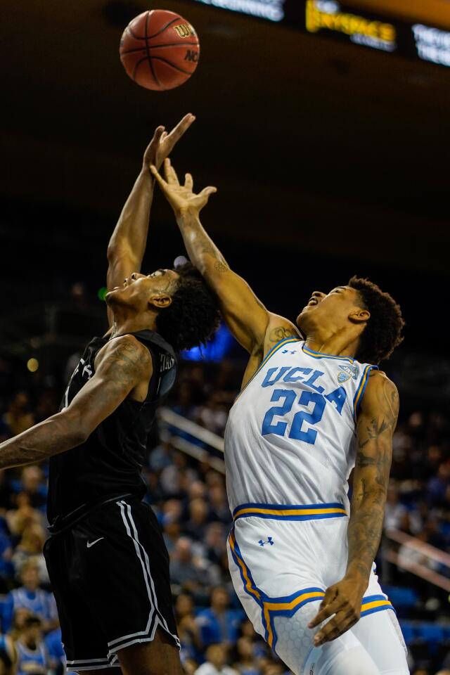 Long Beach State guard Jordan Roberts (2) and UCLA forward Shareef O'Neal (22) battle for a rebound during the first half of a game Nov. 6 at Pauley Pavilion.