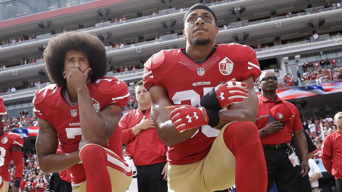 San Francisco 49ers quarterback Colin Kaepernick, left, and safety Eric Reid kneel during the national anthem before a game against the Dallas Cowboys on Oct. 2, 2016.