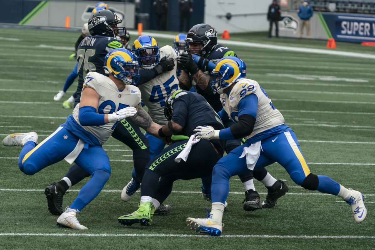 Rams Aaron Donald (99) and Morgan Fox (97) converge to sack Seattle's Russell Wilson last week.