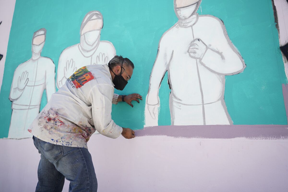 Artist Enrique Chiu painting on the mural project.