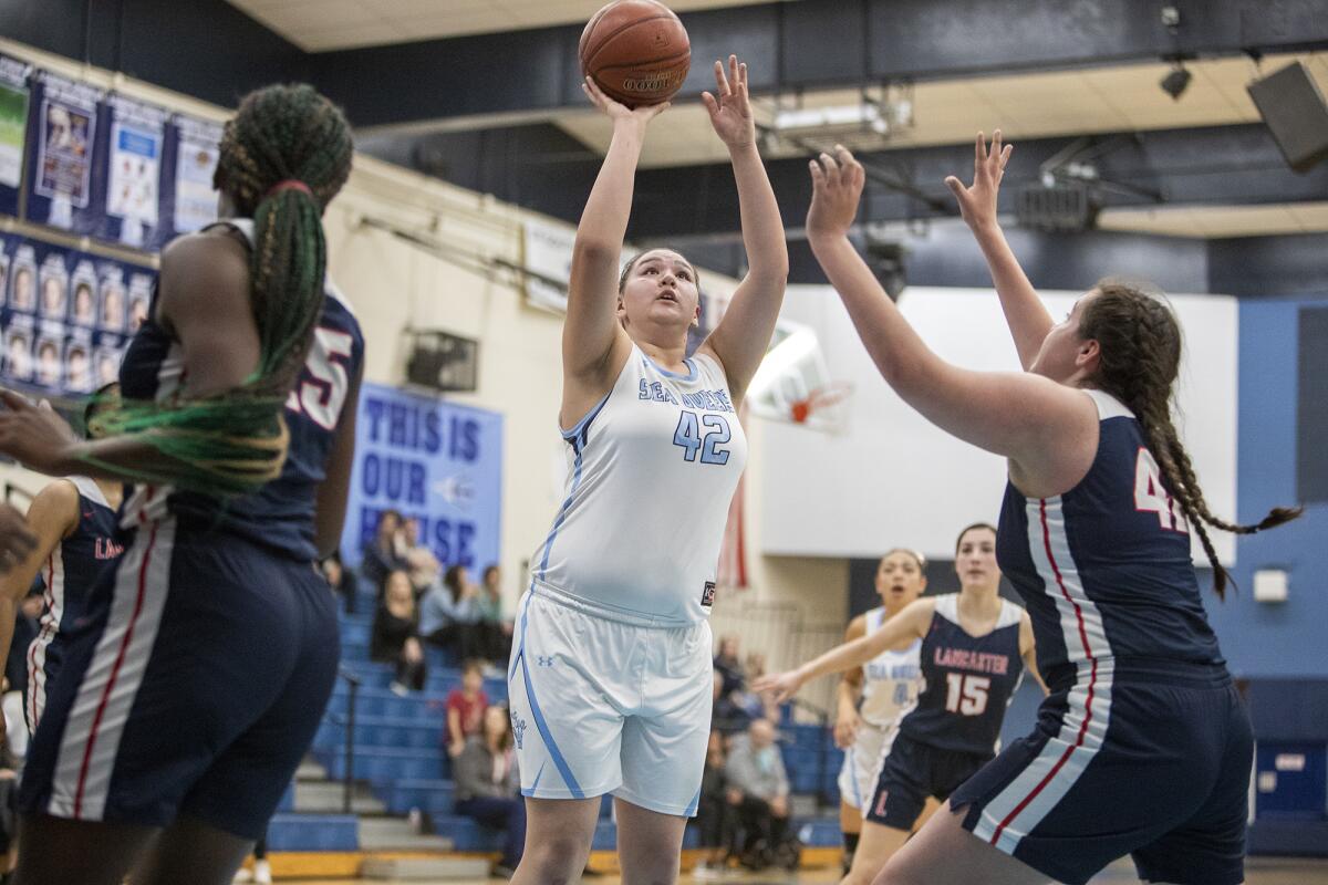 Corona del Mar's Makena Tomlinson goes up for a shot against Lancaster's Vanessa Fletes, right, during a CIF Southern Section Division 3AA quarterfinal playoff game on Wednesday.