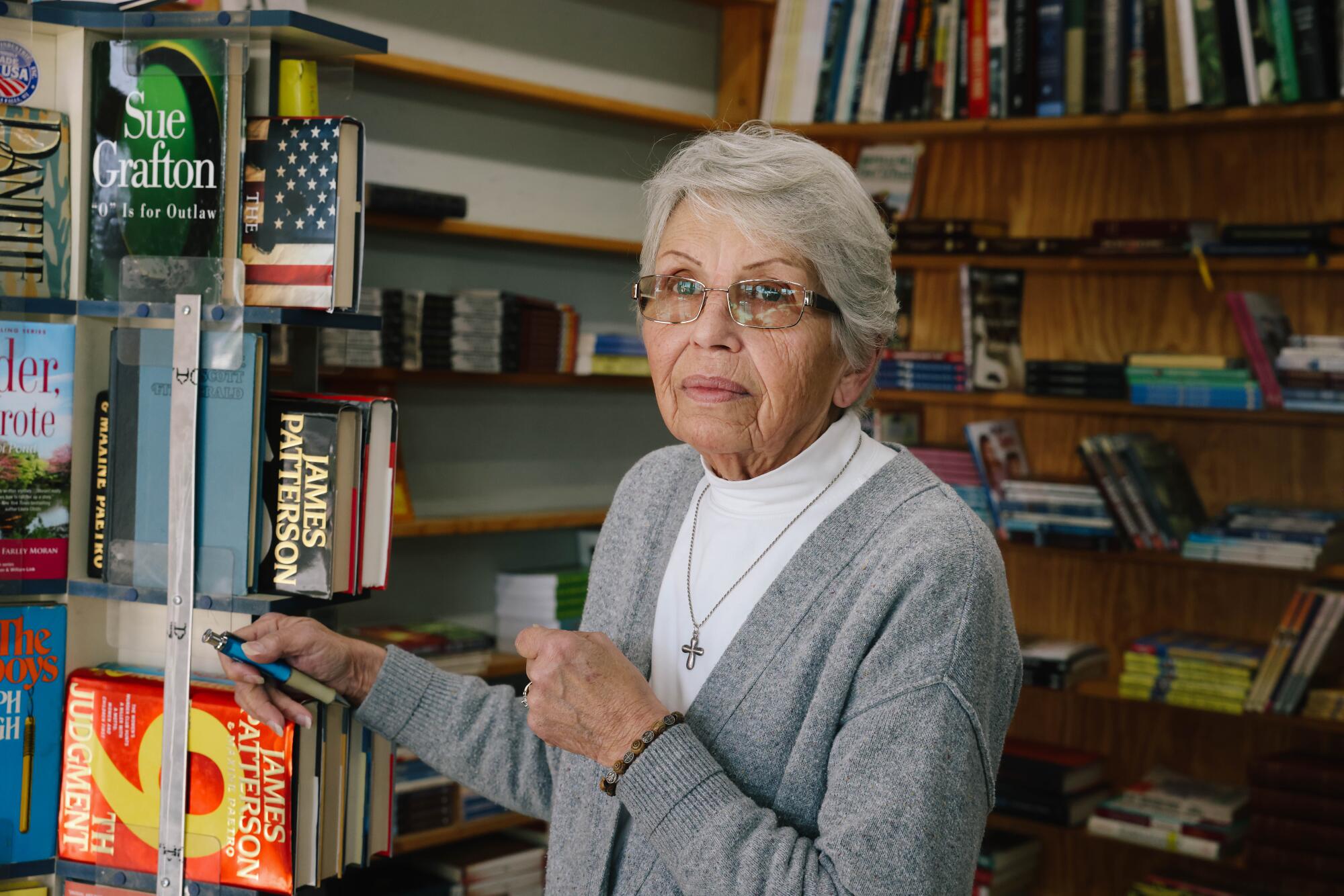 A woman poses among books.
