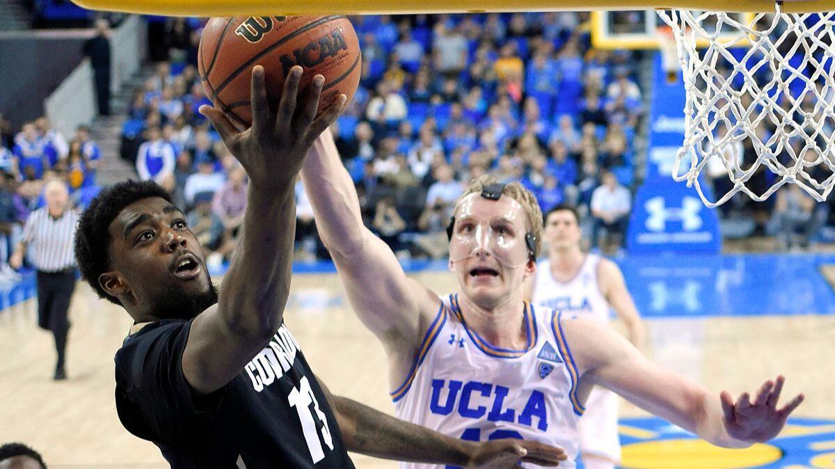 Colorado guard Namon Wright, left, shoots as UCLA center Thomas Welsh defends during the second half on Saturday. Colorado won 68-59.