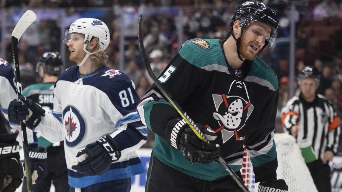 Ducks defenseman Korbinian Holzer, right, reacts as Winnipeg Jets left wing Kyle Connor celebrates center Mark Scheifele's goal during the first period on Wednesday.