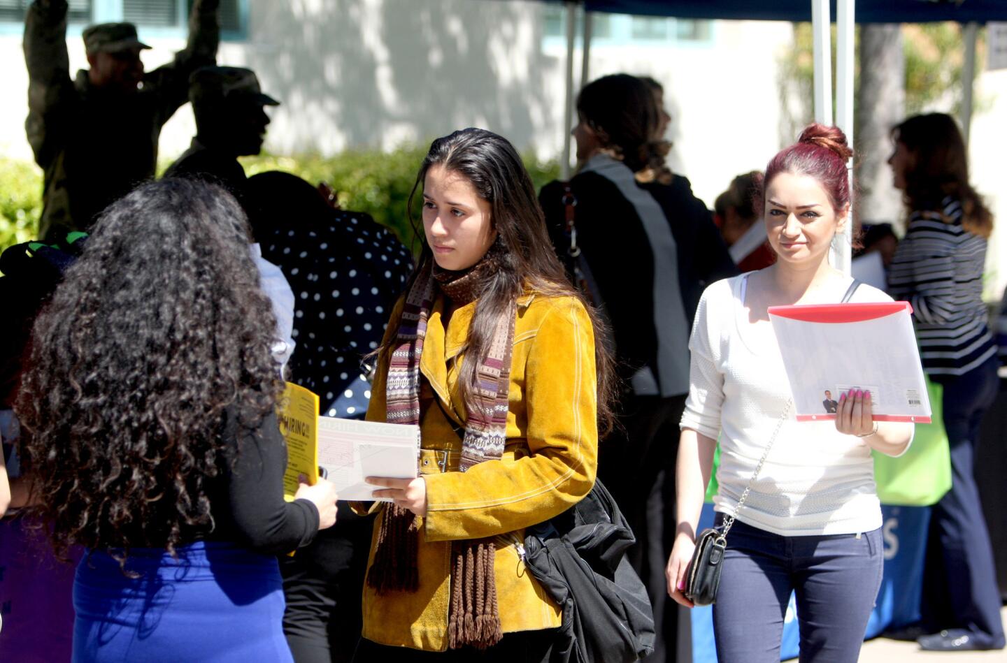 Nursing student Betsaida Esqueda, center, speaks with a job recruiter at the Glendale College Spring Job Fair, on Campus at the college in Glendale on Thursday, March 30, 2017. About 90 employers had representatives offering a wide range of job opportunities from seasonal to part-time and full-time.