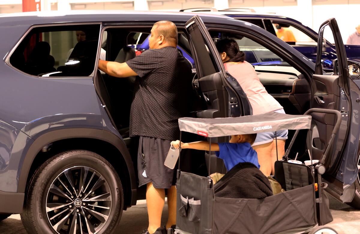 A family checks out a minivan at the O.C Auto Show on Thursday, Oct. 5.
