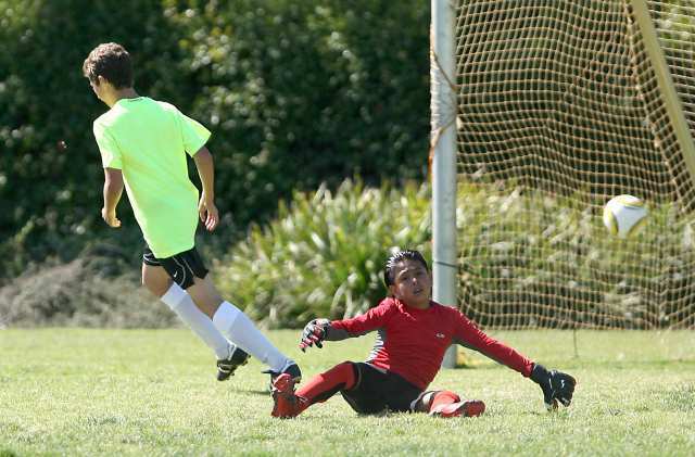 Whittier goalie Jesse Camano, right, is left sprawled out after Mariners Travis Campos, left, scored a quick goal to start the second half of boys championship gold game.