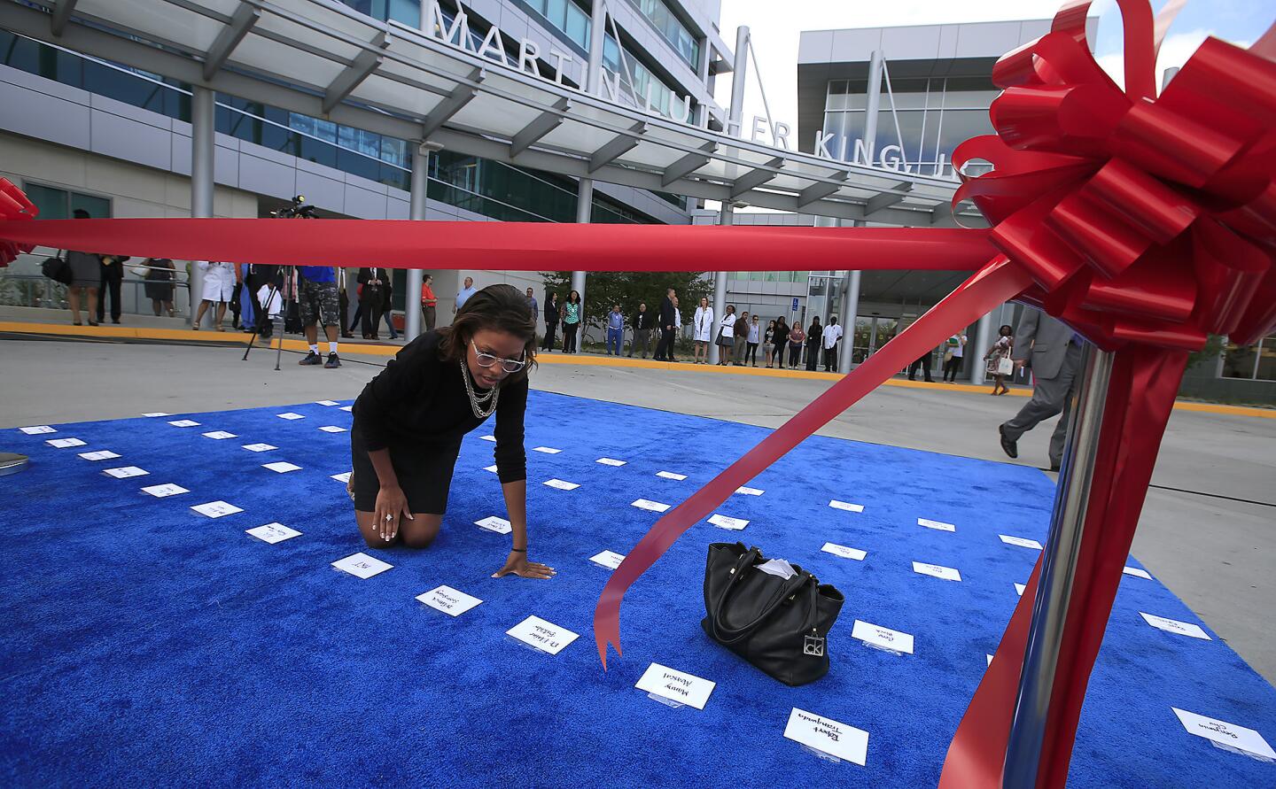 Volunteer Jamarah Harris places name tags on carpet before the ribbon cutting at the Martin Luther King Jr. Community Hospital.