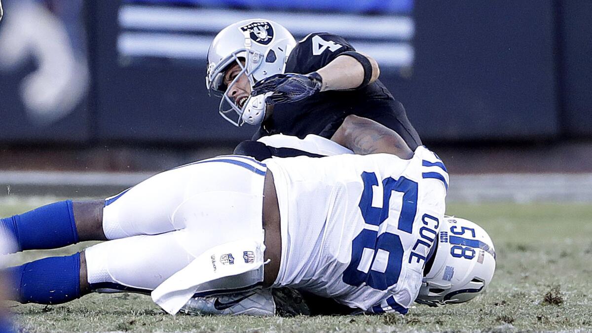 Raiders quarterback Derek Carr sustains a broken leg as he's sacked by Colts outside linebacker Trent Cole (58) during the fourth quarter Saturday.