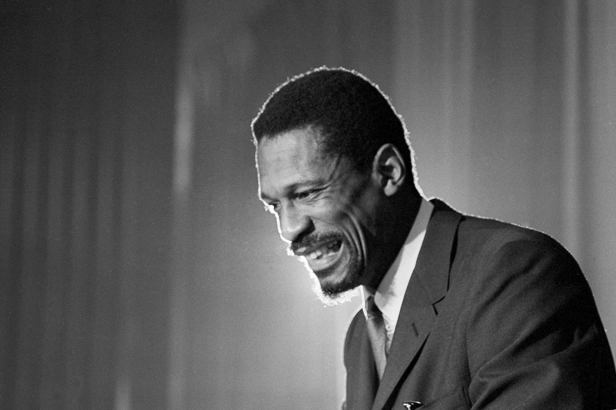 Bill Russell grins at a news conference.