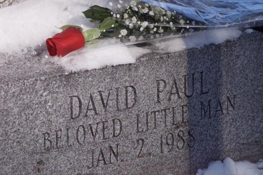In this Jan. 2, 2001 photo, a rose is rests on the gravestone of David Paul at Walnut Grove Cemetery in Meriden, Conn. DNA testing has helped police identify the mother of David Paul, an infant who was abandoned and found frozen to death in a Connecticut parking lot in 1988. Meriden Police Chief Jeffry Cossette announced Tuesday, Jan. 14, 2020, that the mother was Karen Kuzmak Roche, who was 25 when the baby's body was found. She is not expected to face criminal charges. (Chris Angileri/Record-Journal via AP)