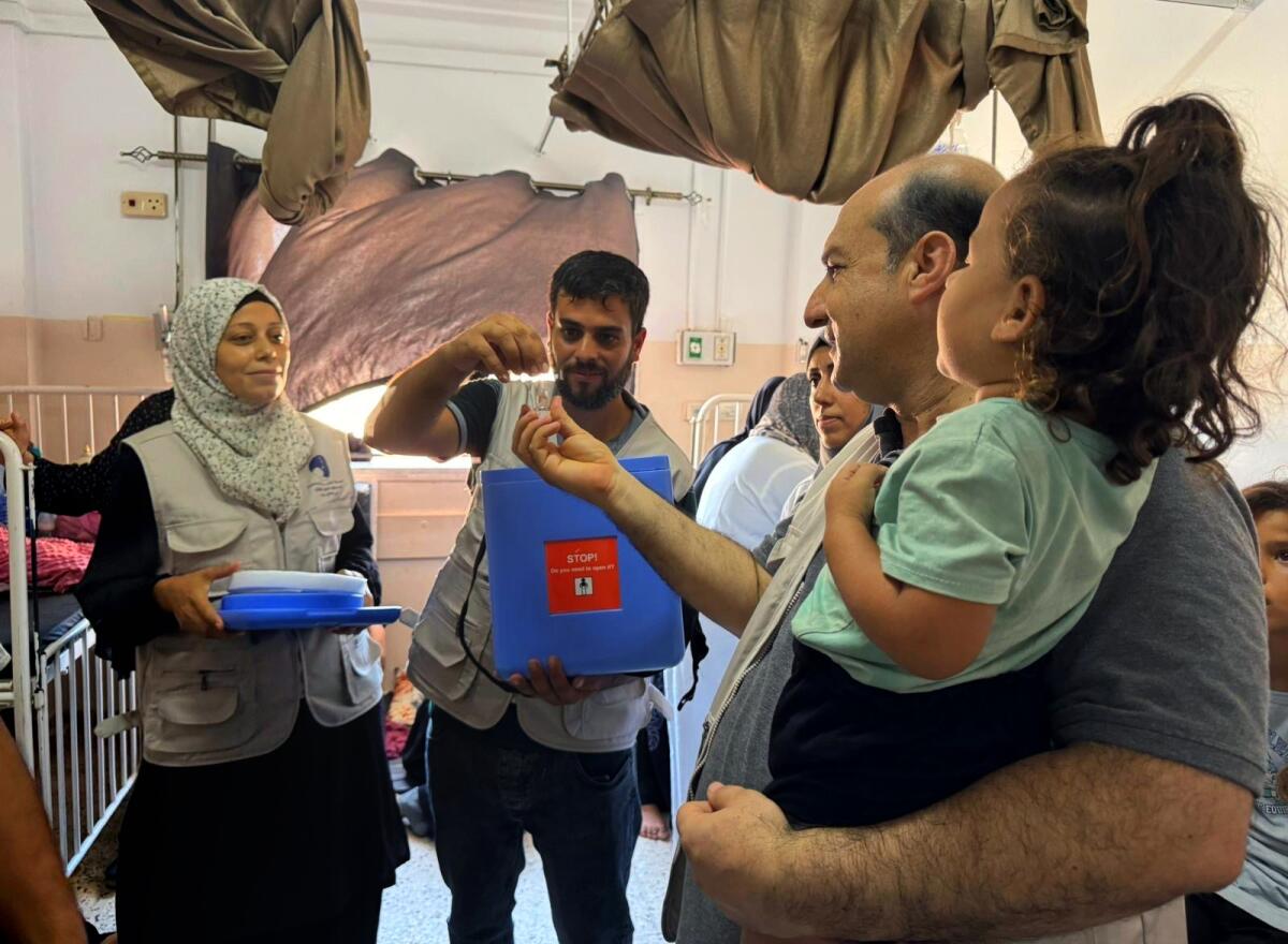 Medical staff and parents at a vaccination site in Khan Younis. 