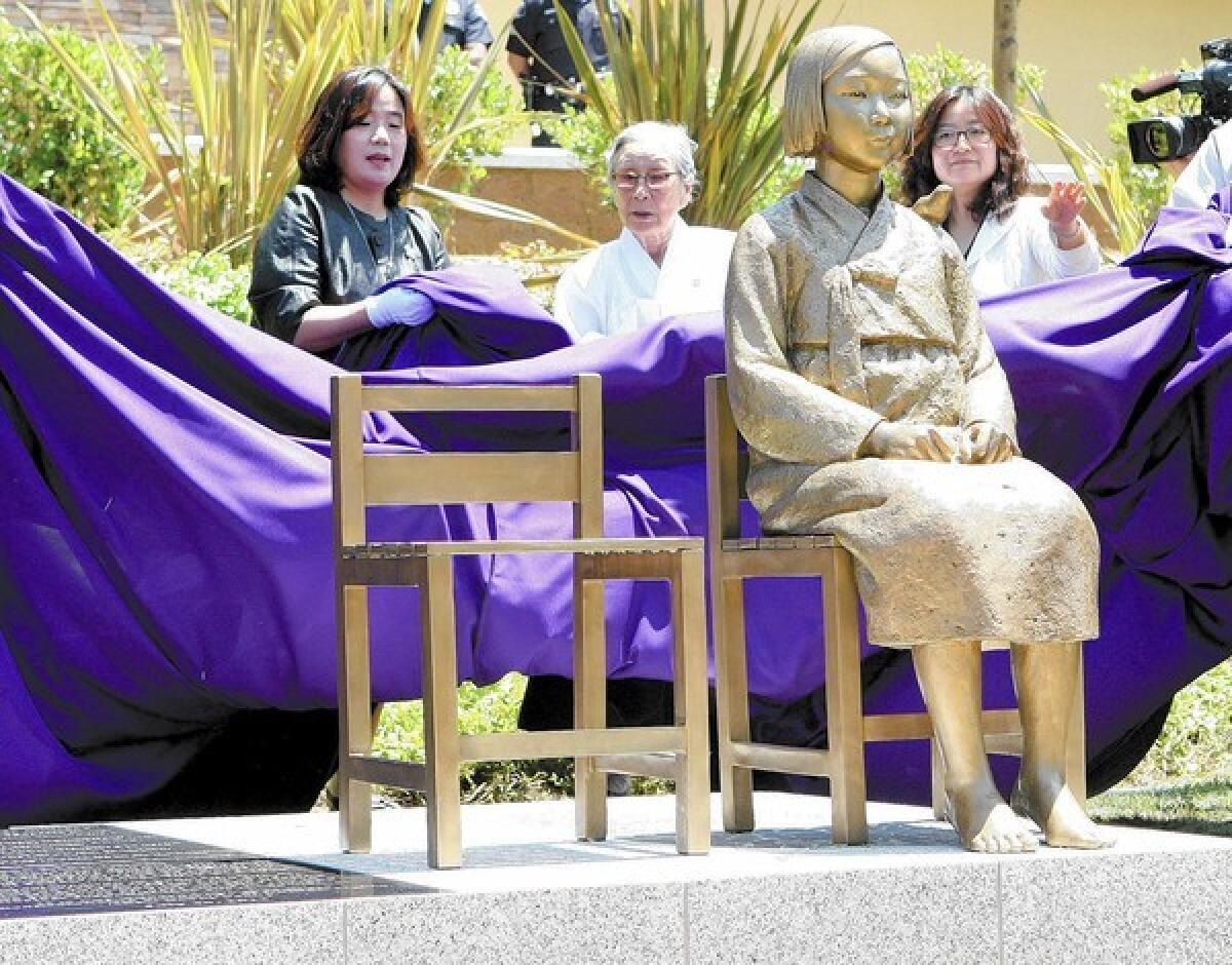 Bok-dong Kim, a comfort woman survivor, stands directly behind the monument at the unveiling ceremony of the Comfort Women Memorial Monument in Glendale on Tuesday, July 30, 2013.