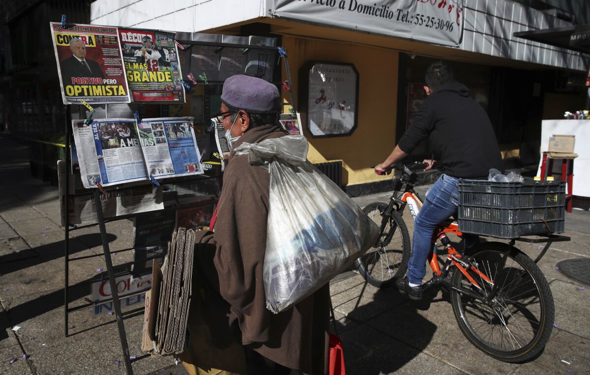 A man reads the front pages of newspapers 