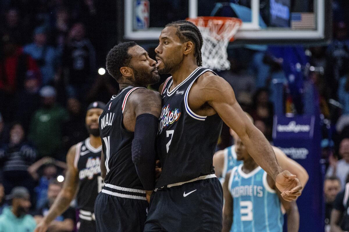 Clippers guard John Wall celebrates with forward Kawhi Leonard after taking the lead against the Charlotte Hornets.