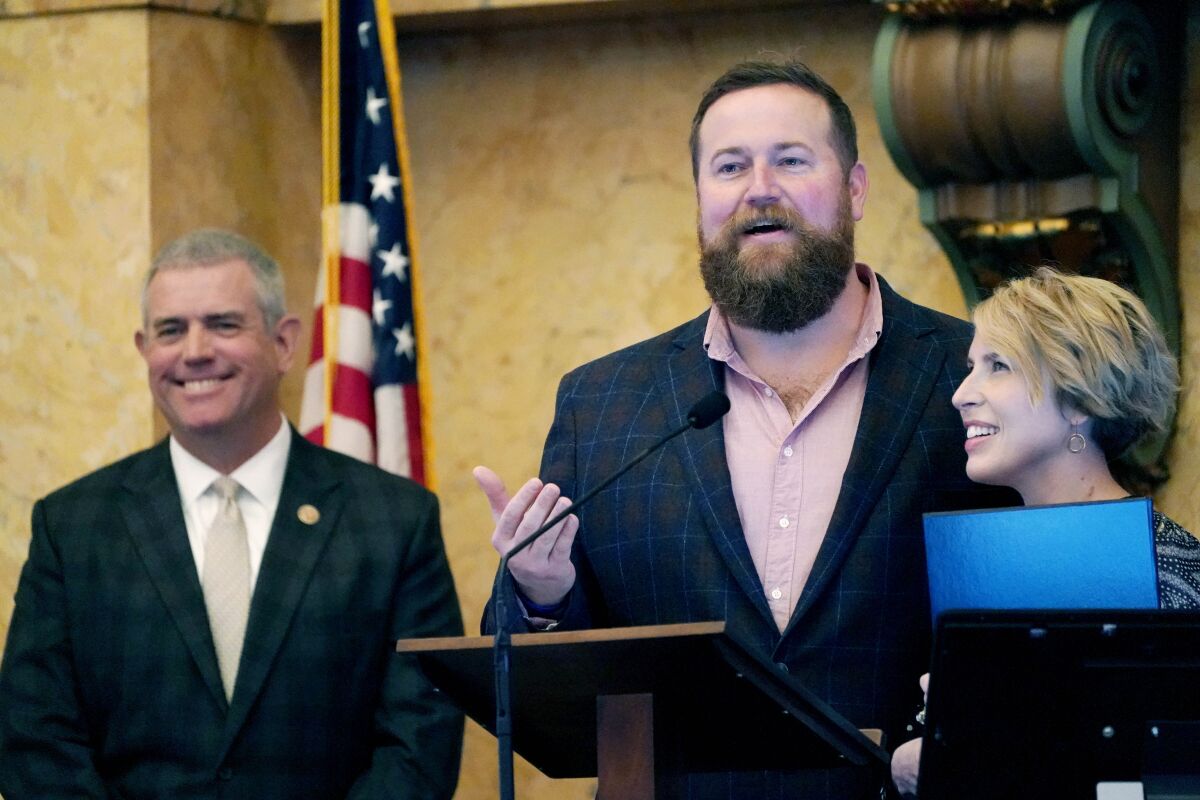 Mississippi House Speaker Philip Gunn, R-Clinton, left, laughs as "Home Town" hosts Ben Napier and Erin Napier, thank lawmakers for a House resolution honoring their HGTV home remodeling show and their work at promoting tourism in their home town of Laurel and the state, while at the Mississippi Capitol in Jackson, Tuesday, March 8, 2022. (AP Photo/Rogelio V. Solis)