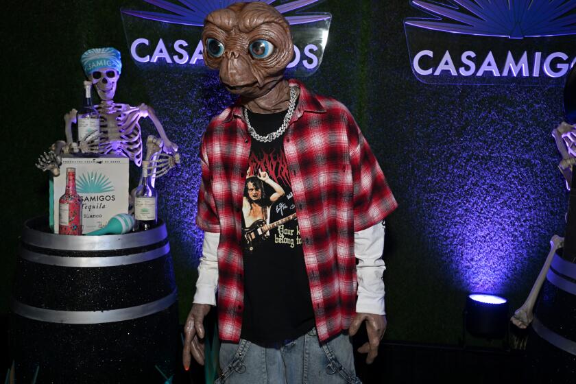 A man wearing an E.T. mask and a flannel shirt