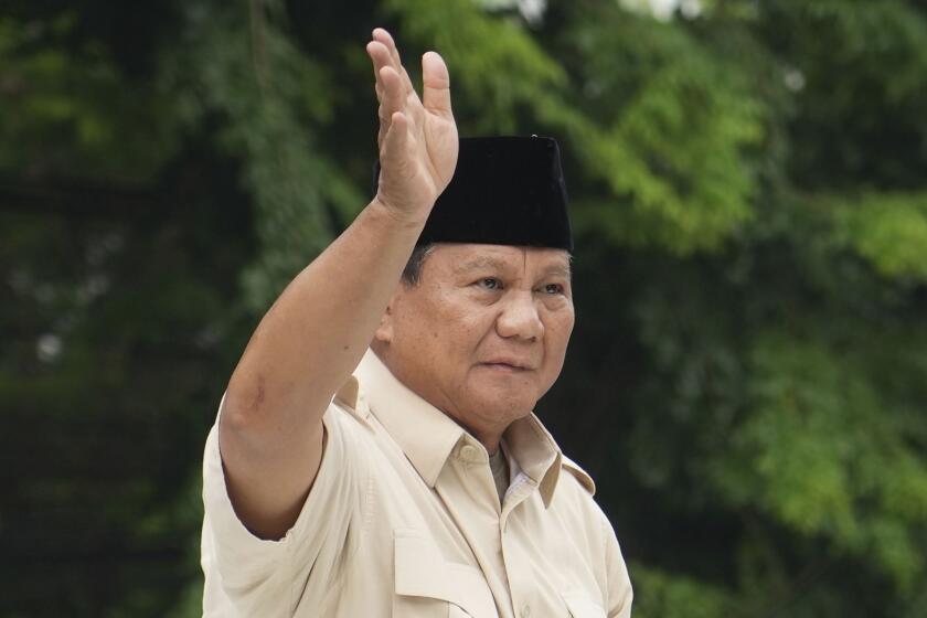 FILE- Indonesian Defense Minister and presidential frontrunner Prabowo Subianto waves at supporters after a visit to his father's grave in Jakarta, Indonesia Thursday, Feb. 15, 2024. Subianto was on Wednesday, March 20, confirmed the victor of last month's presidential election over two former governors who have vowed to contest the result in court. (AP Photo/Tatan Syuflana, File)