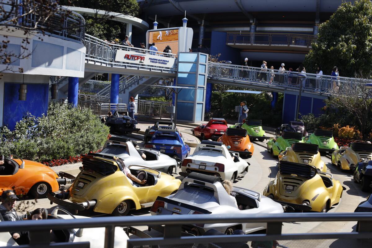 Disneyland visitors wait to exit the Autopia attraction in March.