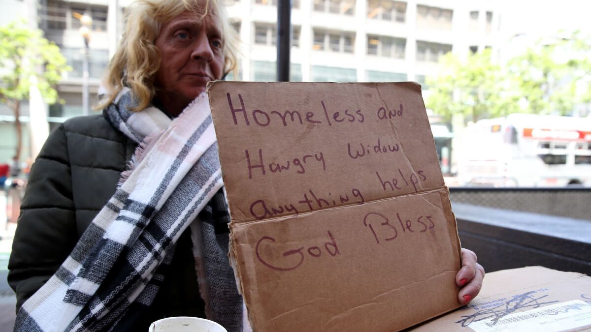 A homeless woman in San Francisco holds a sign as she begs for money in May. Homeless people regularly face "hatred against them as a class of people,” said Jennifer Friedenbach, executive director of the Coalition on Homelessness, a San Francisco advocacy group.